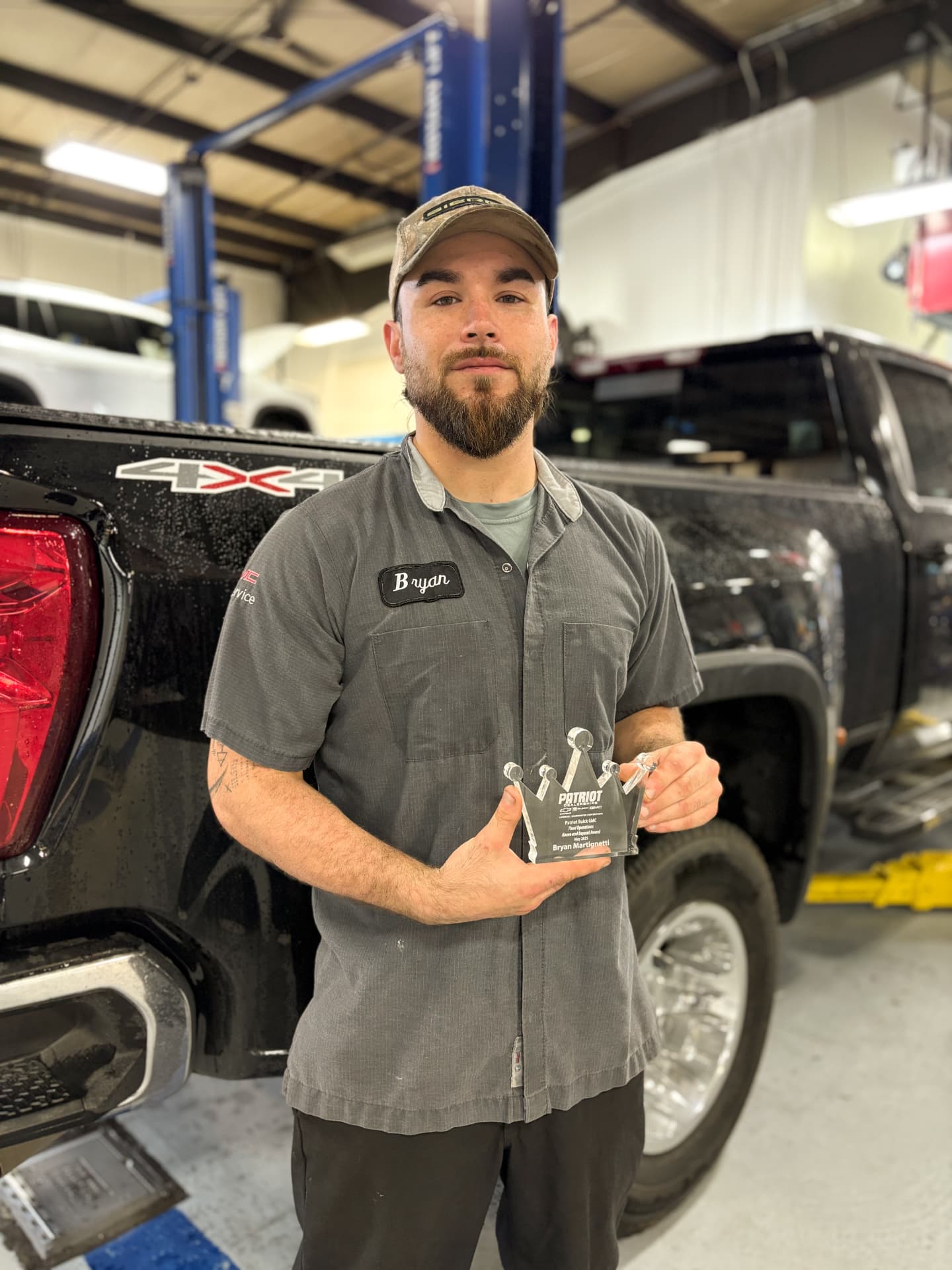 Patriot technician Bryan holding his Above and Beyond Crown award